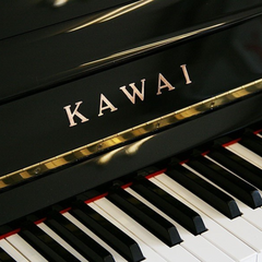 Kawai upright piano fallboard close-up with gold Kawai logo and keys