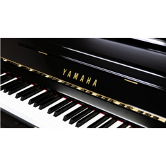 Yamaha U2H keyboard close-up, gold Yamaha logo on polished black fallboard
