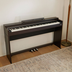 Casio Celviano AP-S200 slim digital piano in brown, in a room beside a floor lamp
