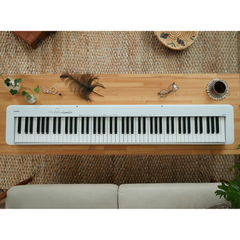 Casio CDP-S110 slim digital piano in white, top-down view on a wooden table