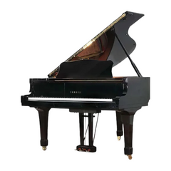 Yamaha G2E grand piano front view, closed fallboard with Yamaha logo and brass pedals